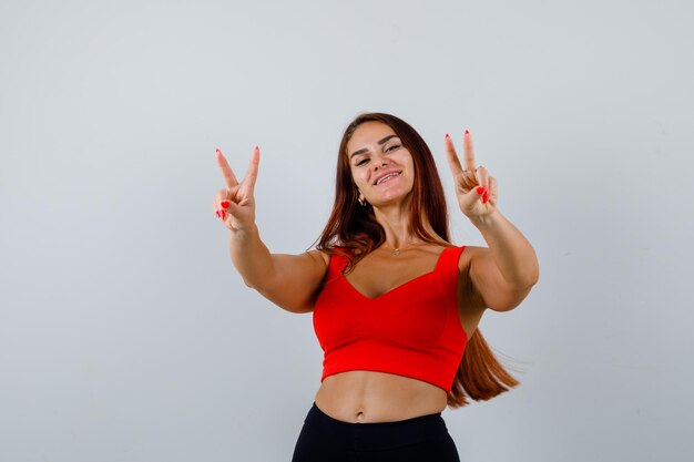 Mulher jovem com cabelo comprido e uma regata laranja