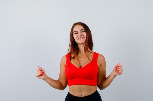 Mulher jovem com cabelo comprido e uma regata laranja