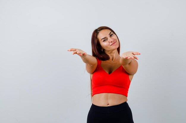 Mulher jovem com cabelo comprido e uma regata laranja