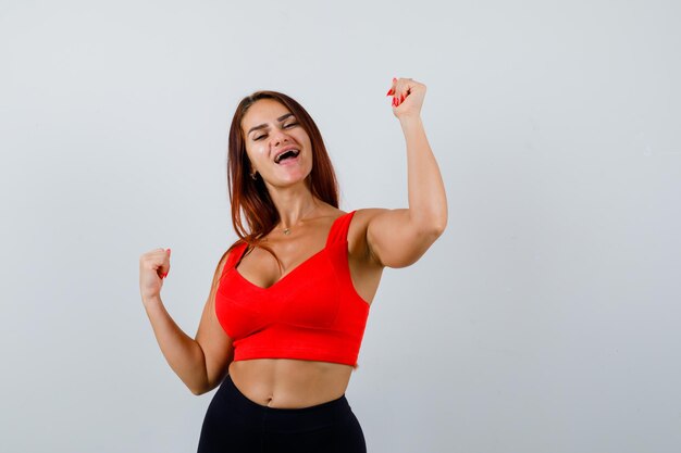 Mulher jovem com cabelo comprido e uma regata laranja