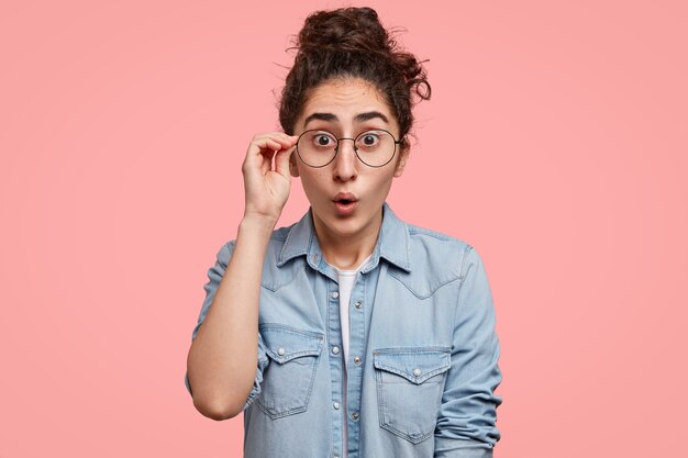 Mulher jovem com cabelo encaracolado e camisa jeans