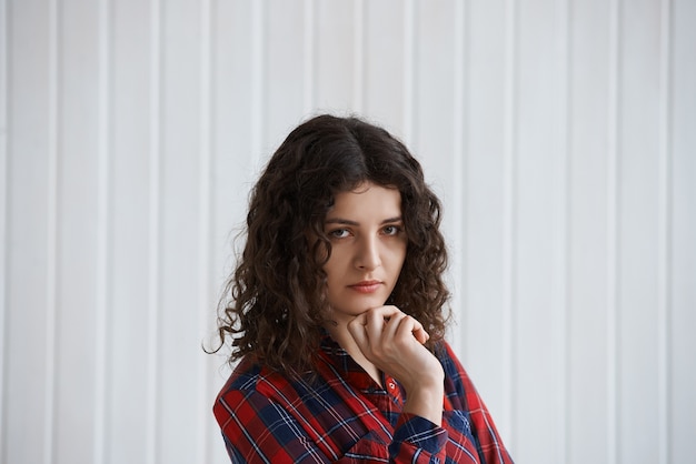 Mulher jovem com cabelo encaracolado e camisa xadrez