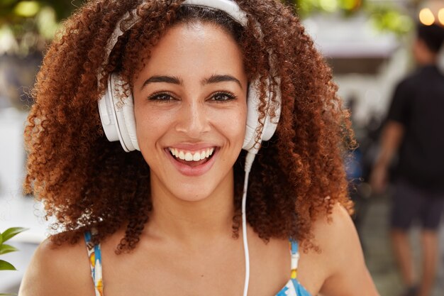 Mulher jovem com cabelo encaracolado e fones de ouvido