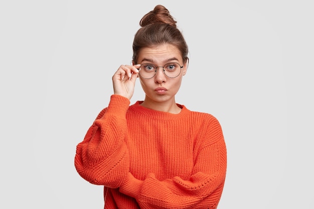 Foto grátis mulher jovem com cabelo preso em um coque e suéter vermelho