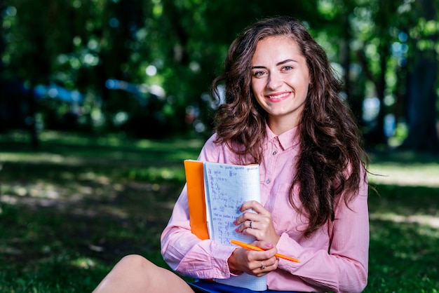 Mulher jovem, com, caderno, parque