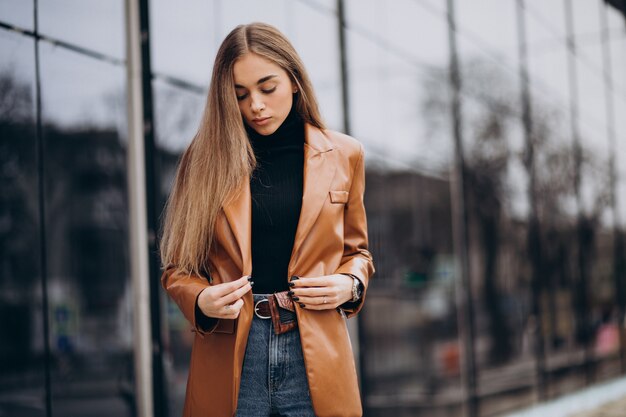 Mulher jovem com casaco andando pela cidade