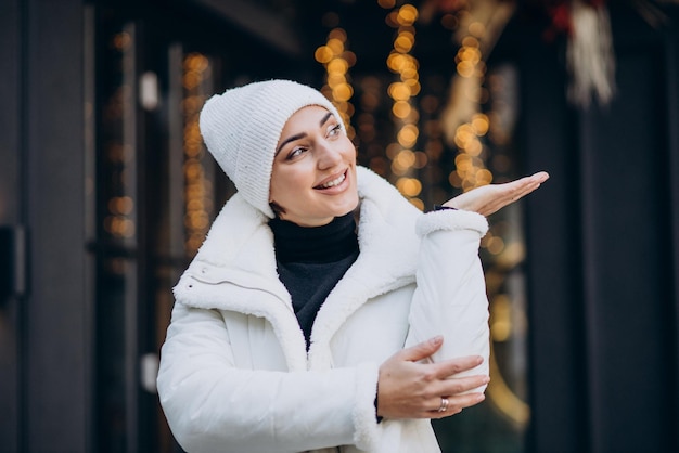 Mulher jovem com chapéu de inverno em pé ao ar livre