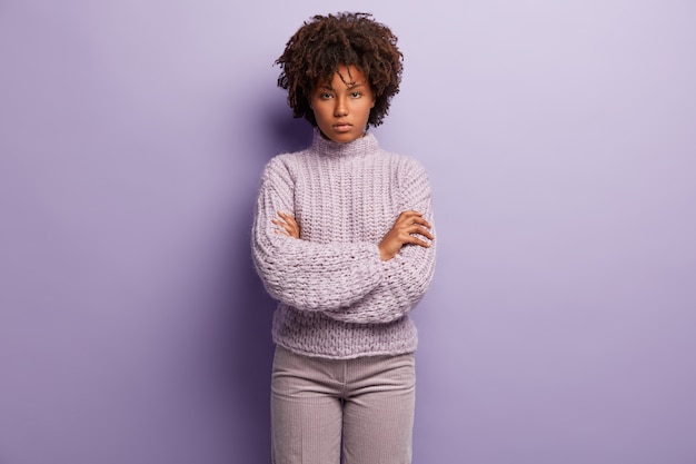 Mulher jovem com corte de cabelo afro e suéter roxo