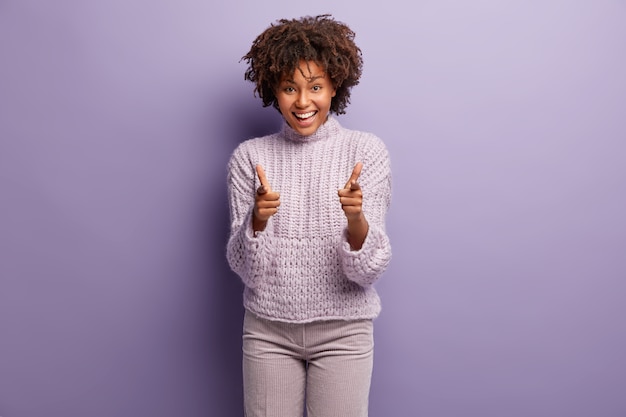 Mulher jovem com corte de cabelo afro e suéter roxo