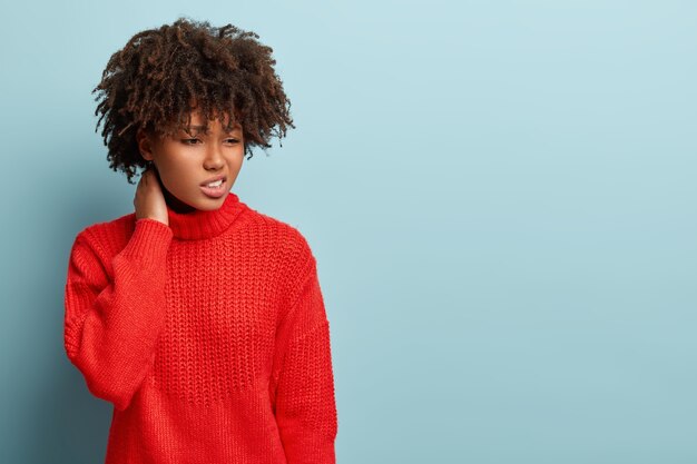 Mulher jovem com corte de cabelo afro e suéter vermelho