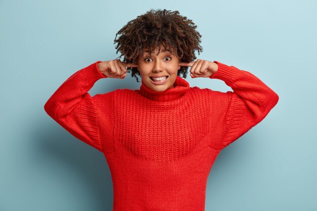 Mulher jovem com corte de cabelo afro e suéter vermelho