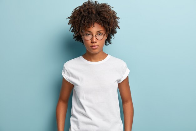 Mulher jovem com corte de cabelo afro vestindo camiseta branca