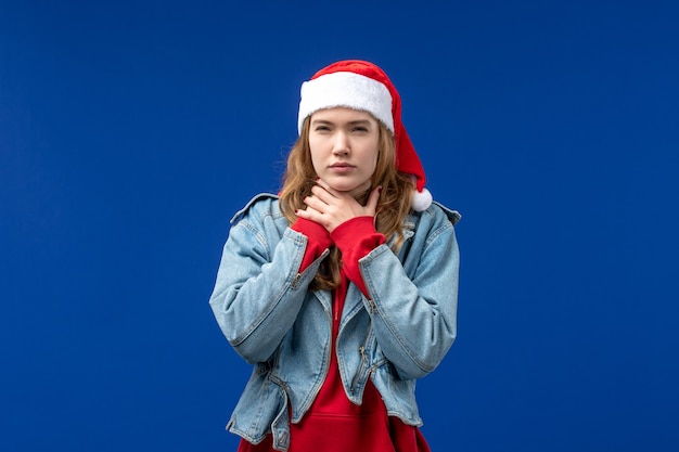 Mulher jovem com dor de garganta na cor de fundo azul da emoção do Natal