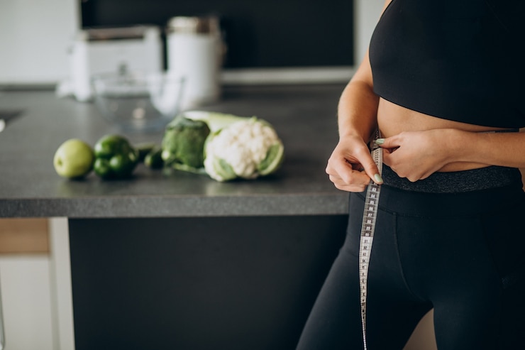 Foto grátis mulher jovem com fita métrica em fita adesiva na cozinha