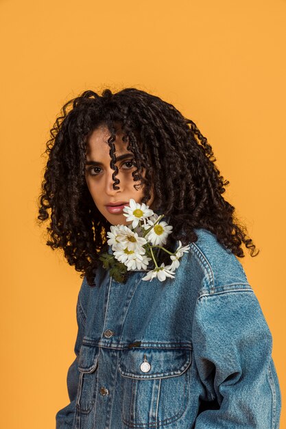 Mulher jovem, com, flores, em, pescoço, olhando câmera