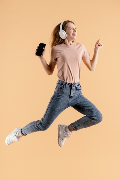 Mulher jovem com fones de ouvido e salto móvel