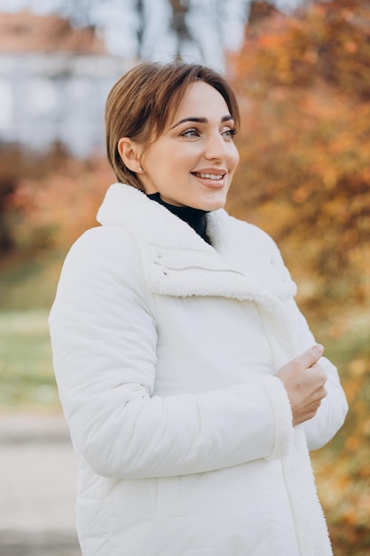 Mulher jovem com jaqueta branca ao ar livre