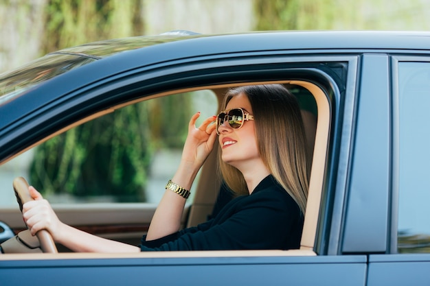 Mulher jovem com óculos de sol ao volante