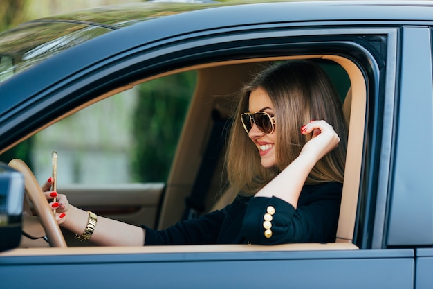 Mulher jovem com óculos de sol ao volante