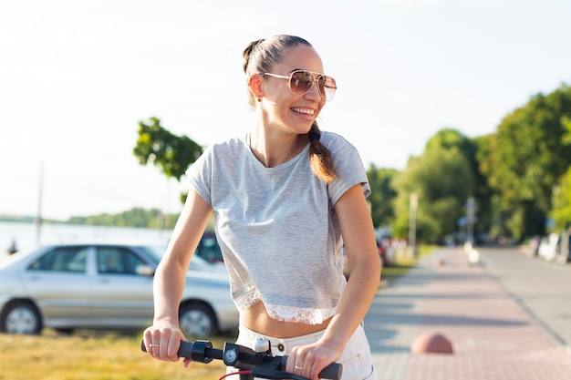 Mulher jovem, com, óculos de sol, ligado, scooter