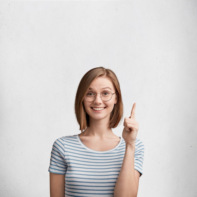 Mulher jovem com óculos redondos e camiseta listrada