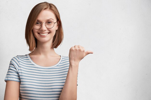 Mulher jovem com óculos redondos e camiseta listrada