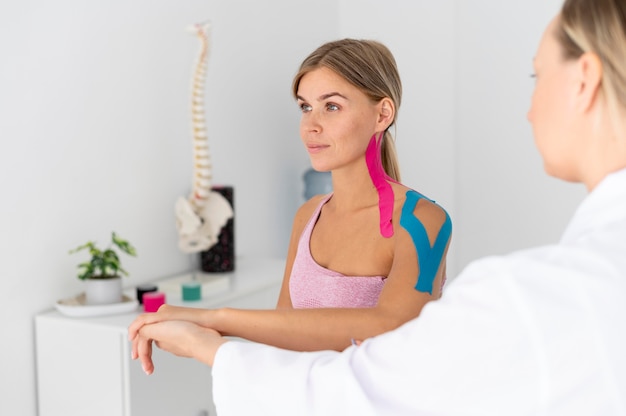 Foto grátis mulher jovem com problemas nas costas fazendo tratamento de fisioterapia