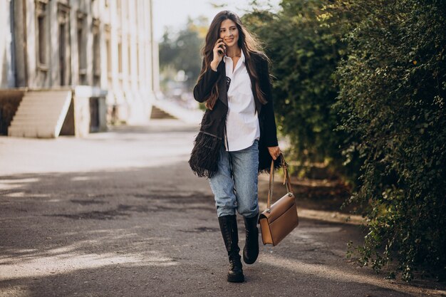 Mulher jovem com roupa da moda caminhando no parque