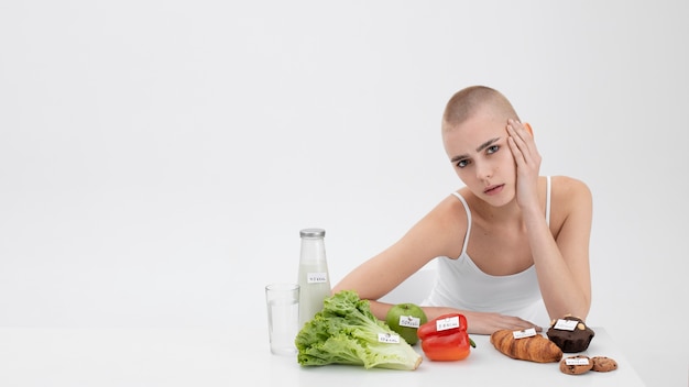 Mulher jovem com transtorno alimentar ao lado de comida com número de calorias