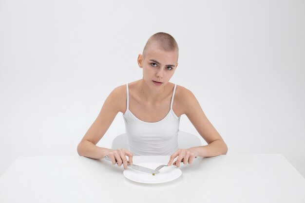 Mulher jovem com um distúrbio alimentar com vontade de comer uma ervilha