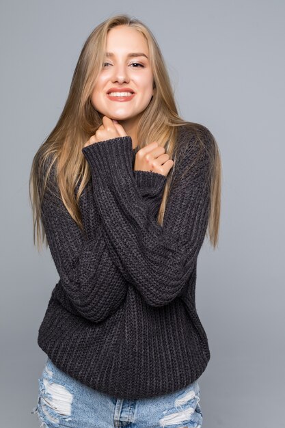 Mulher jovem com um sorriso amigável e pensativo, olhando de lado para a câmera com a cabeça inclinada para o lado e copia o espaço