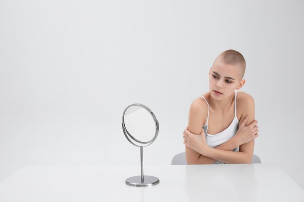 Mulher jovem com um transtorno alimentar se olhando no espelho