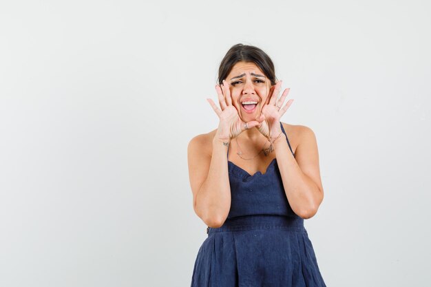 Mulher jovem com um vestido gritando ou anunciando algo e parecendo animada