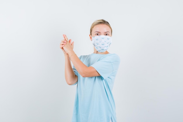 Mulher jovem com uma camiseta azul e uma máscara médica