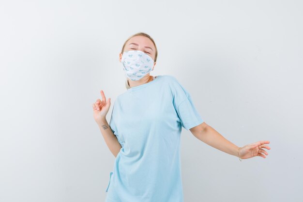 Mulher jovem com uma camiseta azul e uma máscara médica