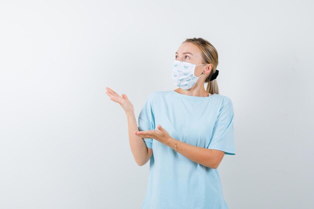 Mulher jovem com uma camiseta azul e uma máscara médica