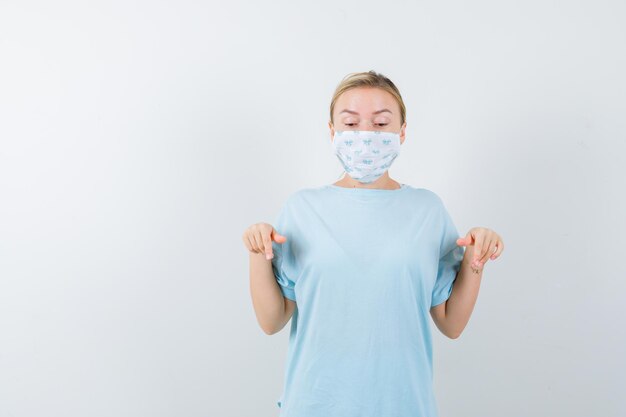 Mulher jovem com uma camiseta azul e uma máscara médica