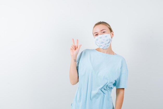 Mulher jovem com uma camiseta azul e uma máscara médica