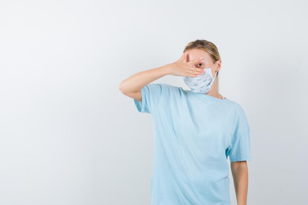 Mulher jovem com uma camiseta azul e uma máscara médica