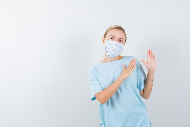 Mulher jovem com uma camiseta azul e uma máscara médica