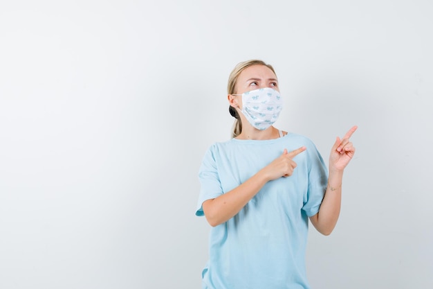 Mulher jovem com uma camiseta azul e uma máscara médica