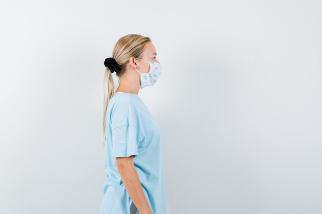 Mulher jovem com uma camiseta azul e uma máscara médica