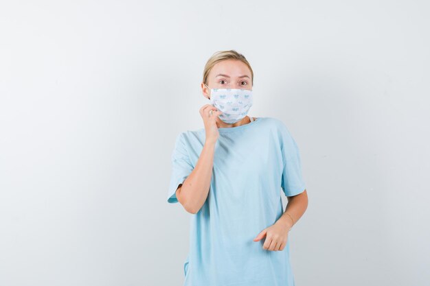 Mulher jovem com uma camiseta azul e uma máscara médica