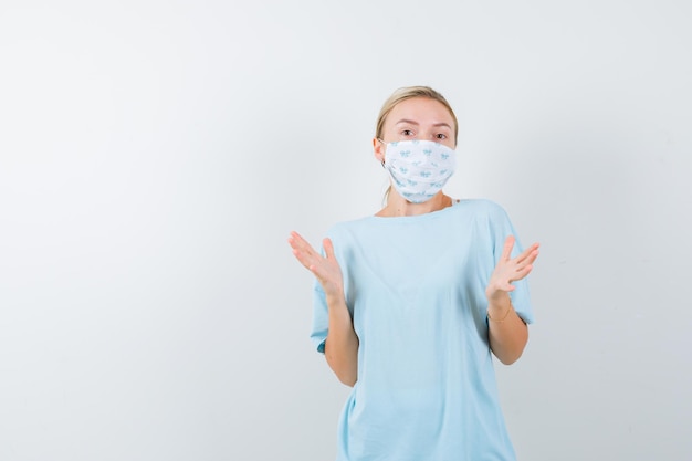 Mulher jovem com uma camiseta azul e uma máscara médica