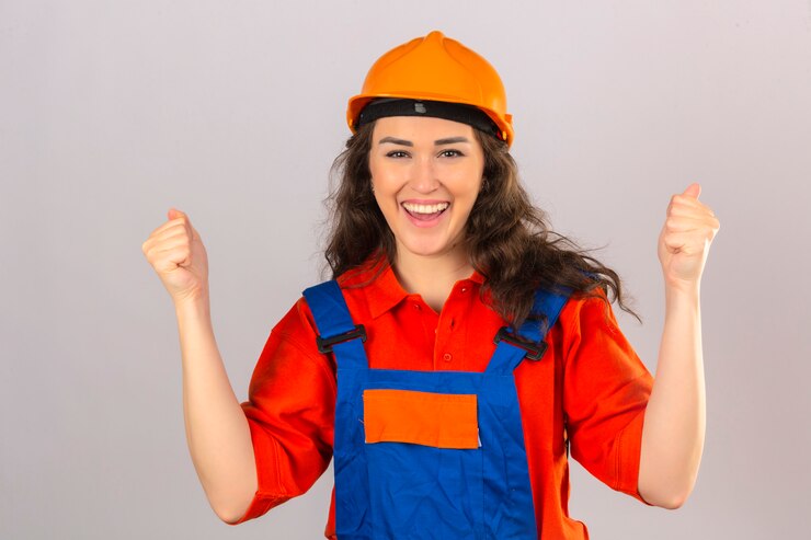 Foto grátis mulher jovem construtor em uniforme de construção e capacete de segurança feliz e animado comemorando a vitória expressando grande sucesso, levantando os punhos sobre parede branca isolada