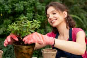 Foto grátis mulher jovem cuidando de suas plantas em uma estufa