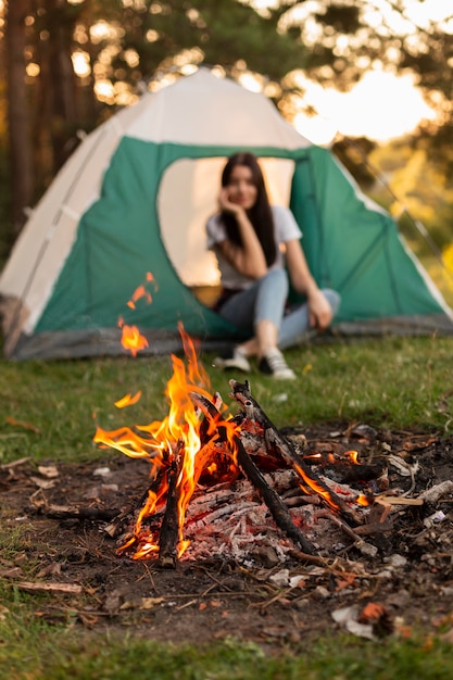 Mulher jovem curtindo uma fogueira na natureza