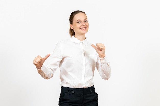 Mulher jovem de blusa branca com expressão animada na luz de fundo branco trabalho de escritório emoção feminina de frente