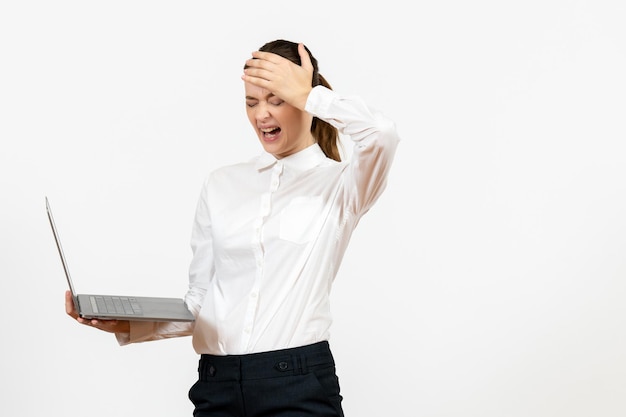 Mulher jovem de blusa branca usando o laptop no fundo branco escritório de trabalho feminino sentimento de emoção modelo de vista frontal
