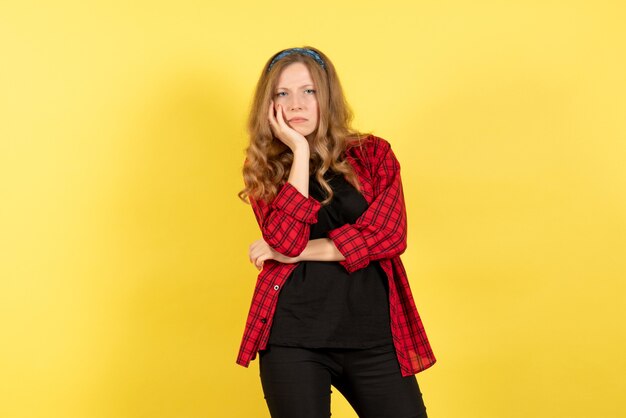 Mulher jovem de camisa quadriculada vermelha, vista frontal, posando em fundo amarelo garota humana emoção cor modelo mulher